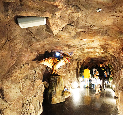 동굴모형안의 공룡모형과 관람객들